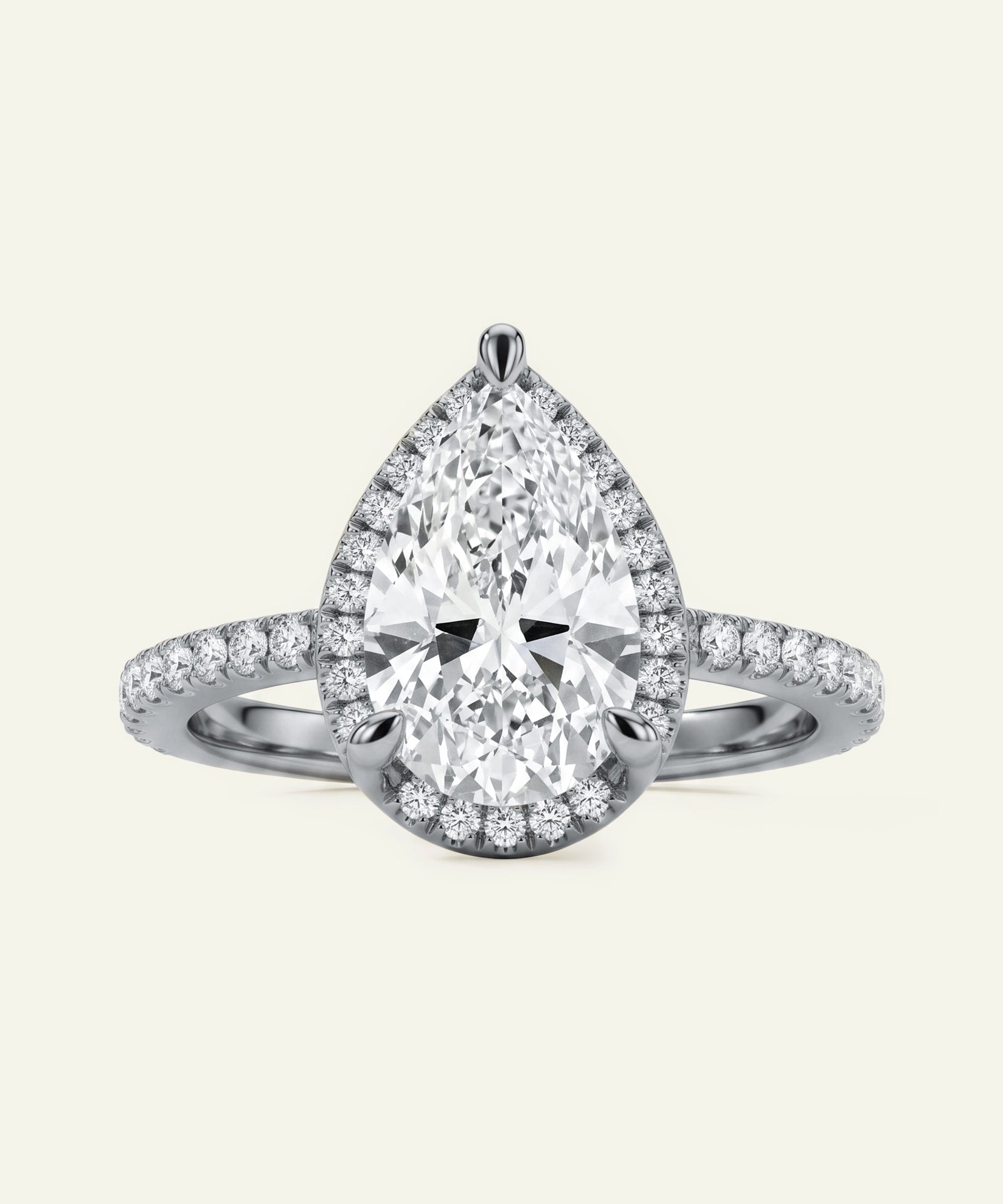 Diamond ring with pear-shaped center stone on a light gray background
