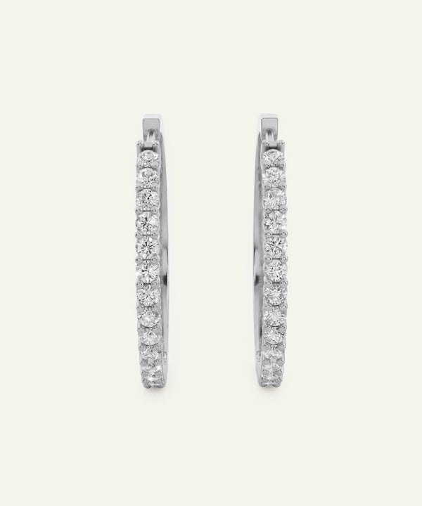 Pair of diamond hoop earrings on a light gray background