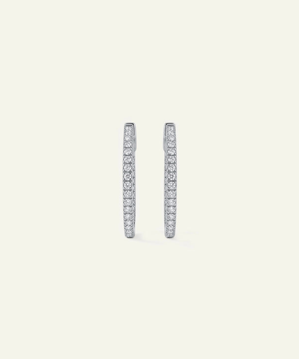Pair of diamond hoop earrings on a light gray background