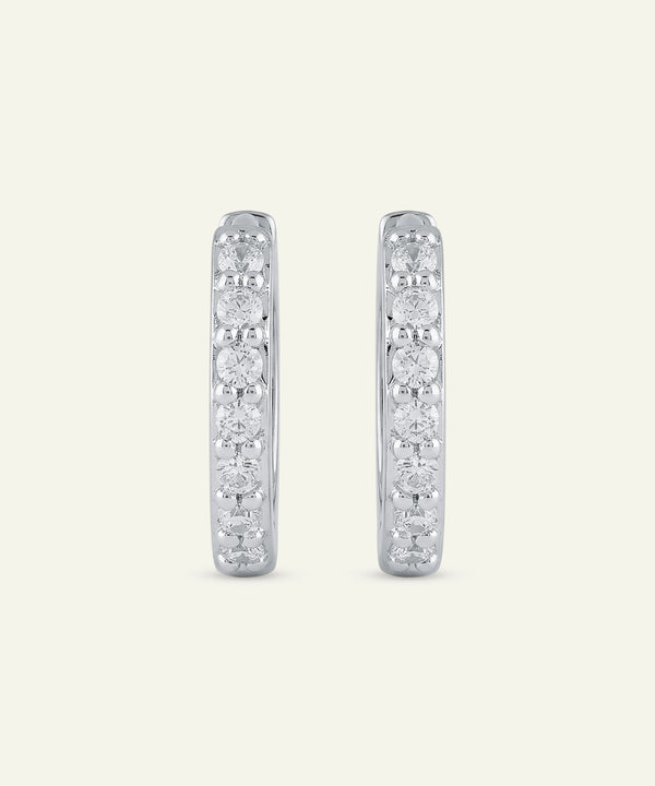 Pair of diamond hoop earrings on a light gray background