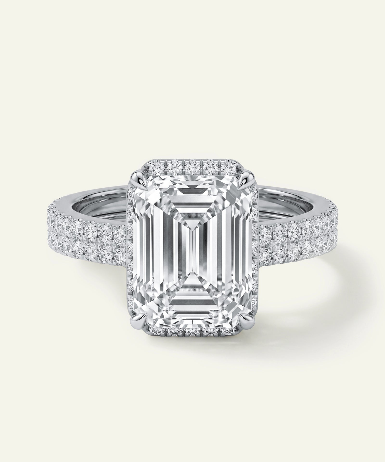 Diamond ring with emerald-cut center stone on a white background