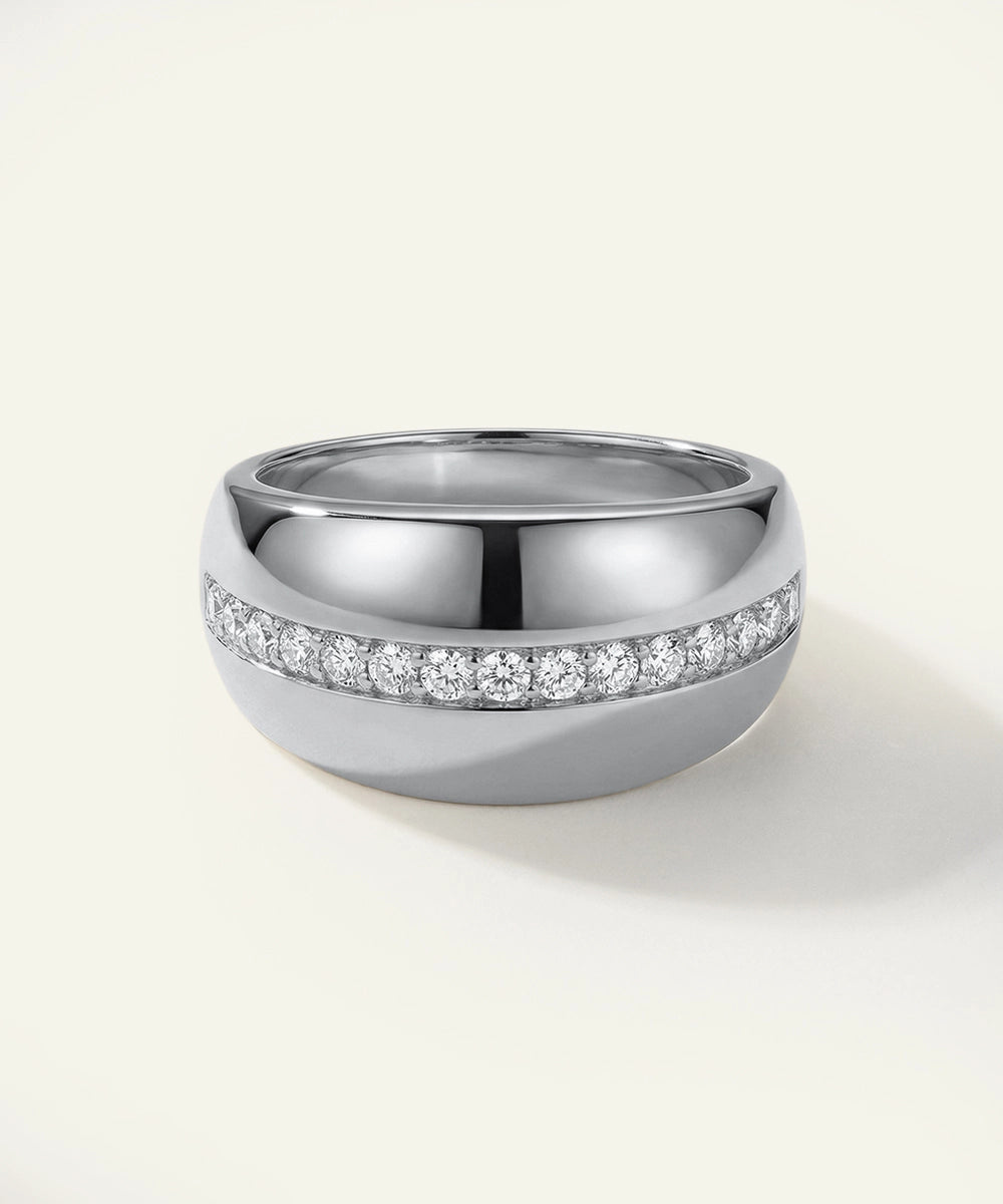 Silver ring with embedded diamonds on a light gray background