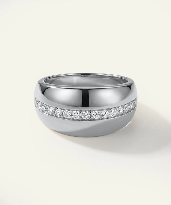 Silver ring with embedded diamonds on a light gray background