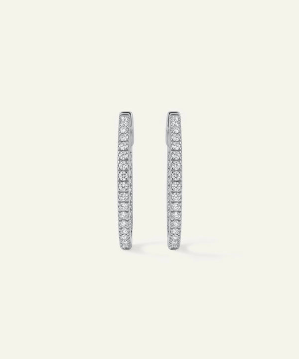Pair of diamond hoop earrings on a light gray background