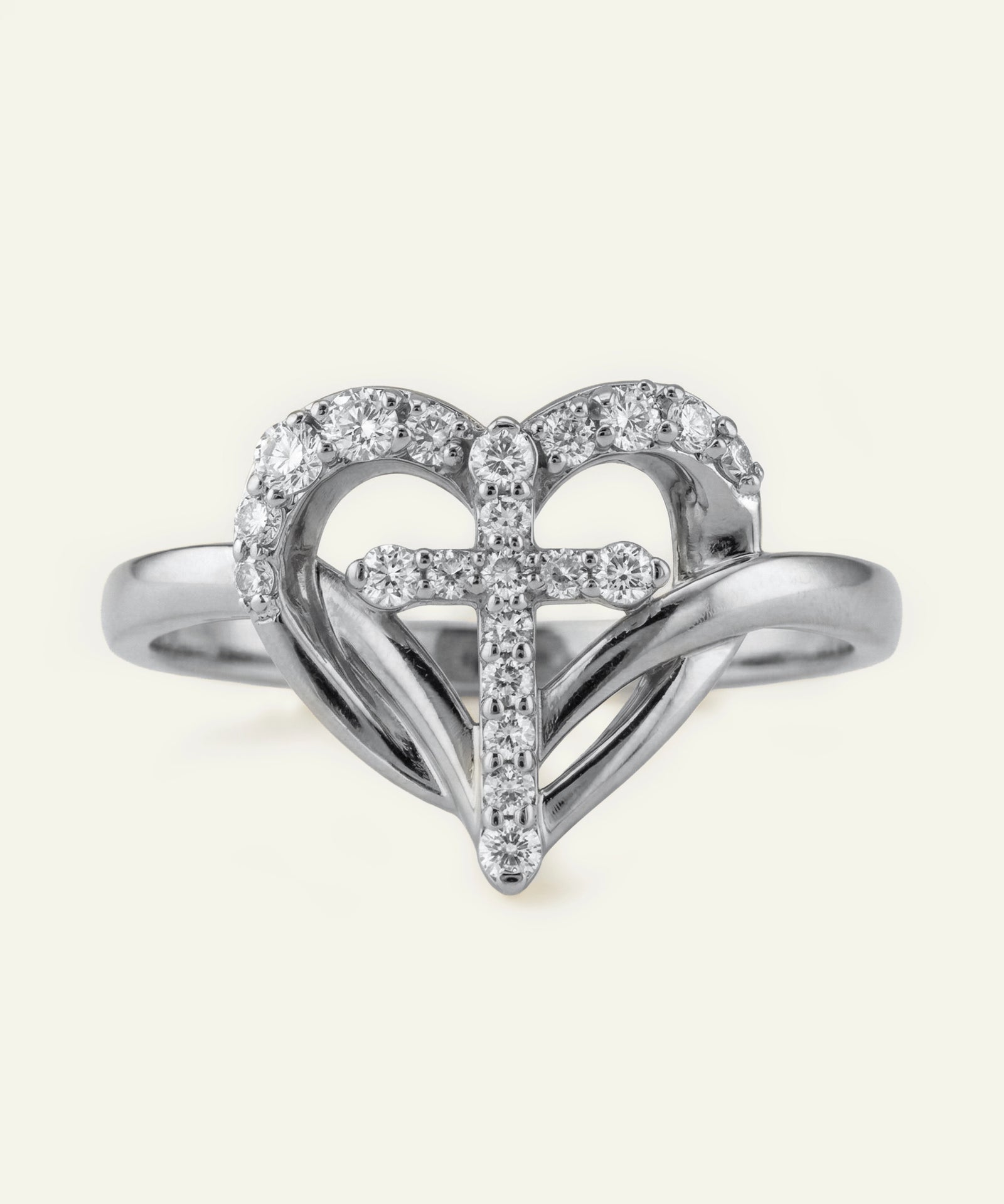 Silver heart-shaped ring with embedded diamonds on a white background