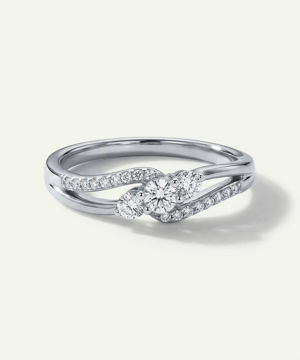 Silver ring with diamond accents on a light gray background