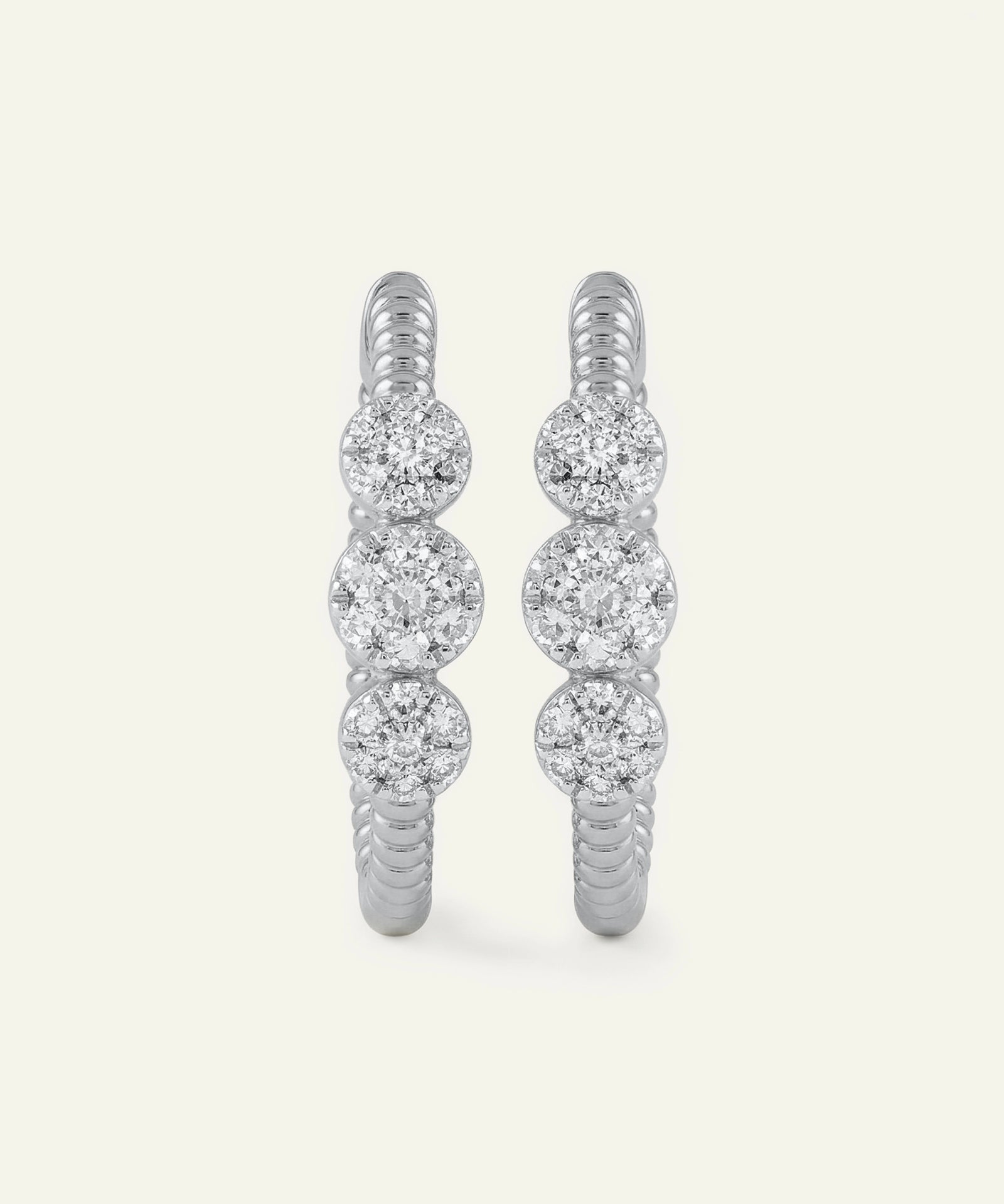 Pair of diamond hoop earrings on a light gray background
