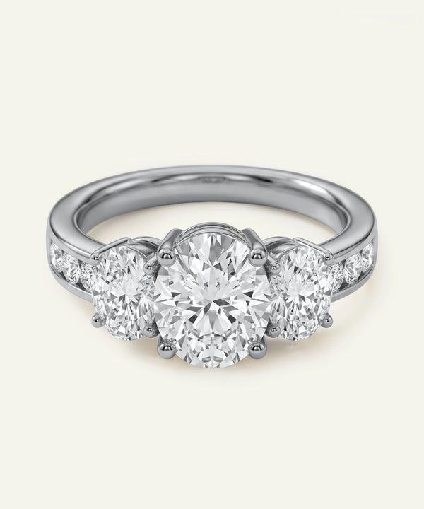 Diamond ring with three circular diamonds on a light gray background