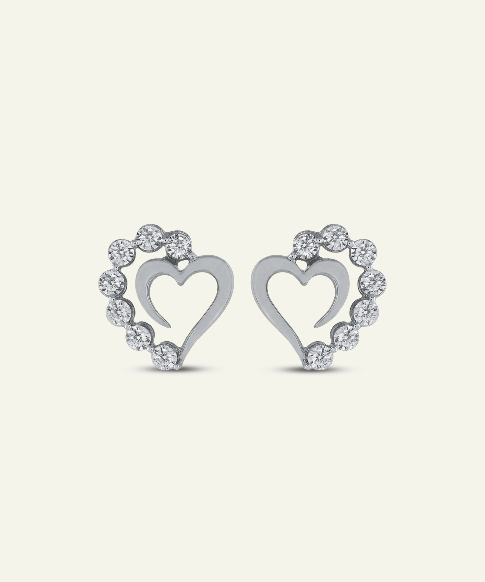 Pair of silver heart-shaped earrings with diamond accents on a light gray background