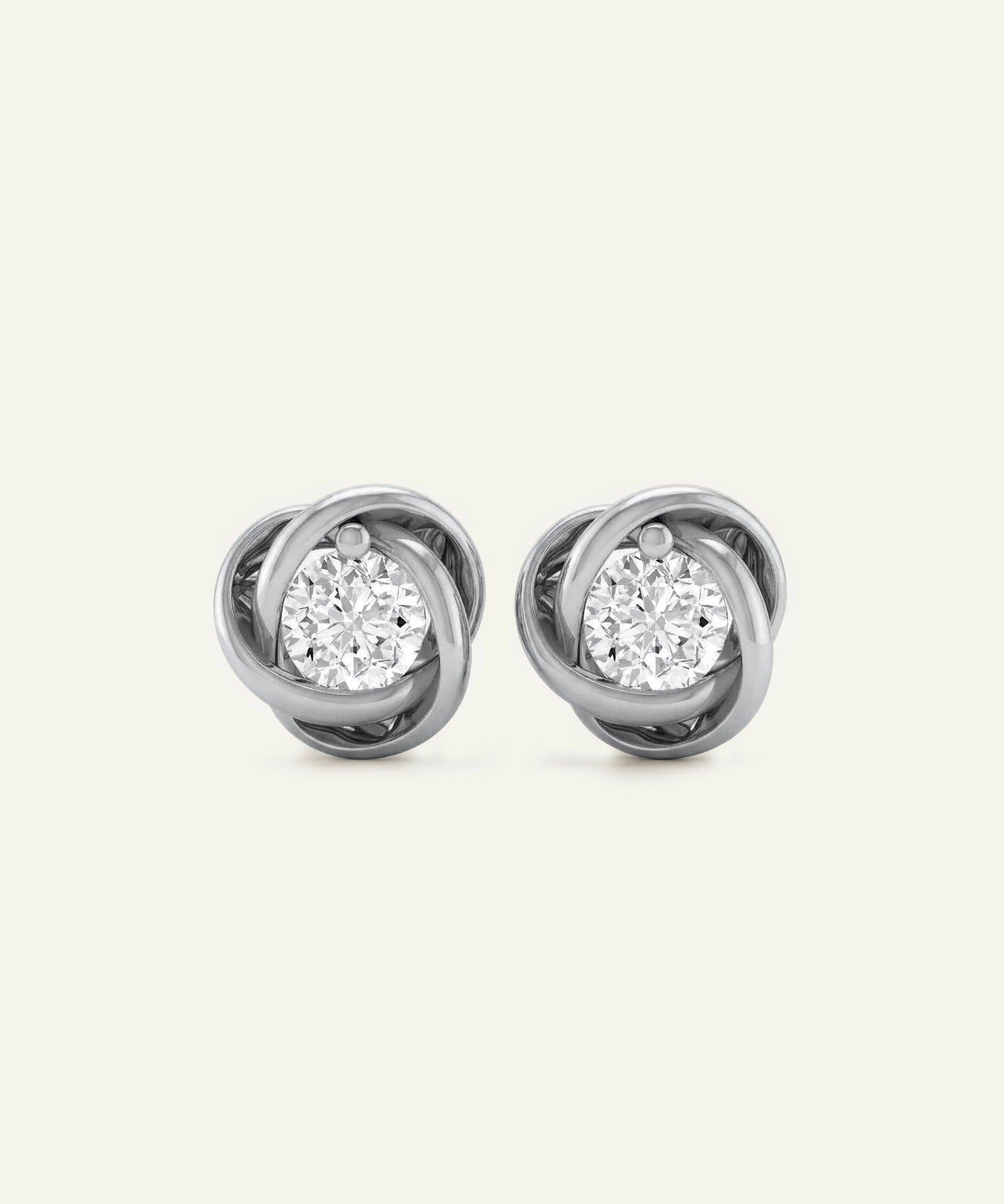 Pair of diamond stud earrings on a light gray background