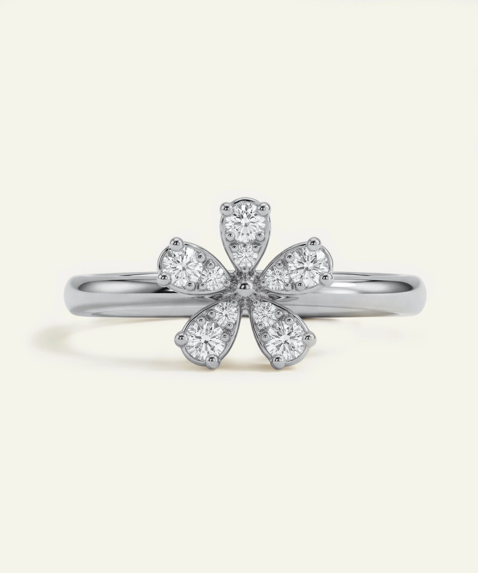 Silver ring with diamond flower design on a light gray background