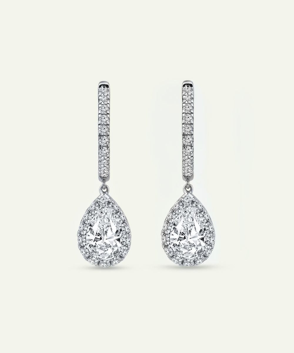 Pair of diamond teardrop earrings on a light gray background
