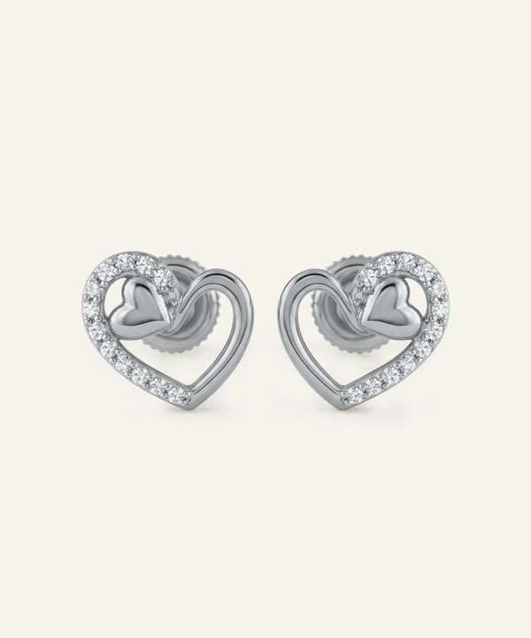 Pair of silver heart-shaped earrings with small diamonds on a white background