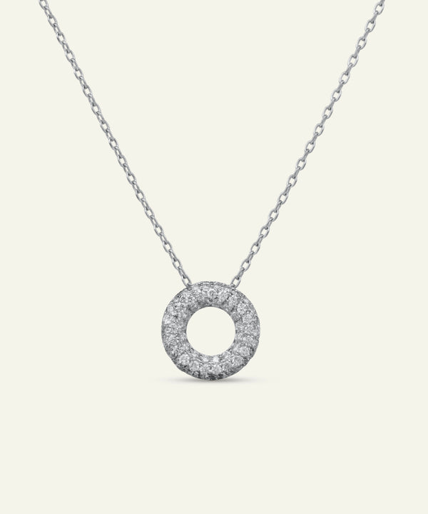 Silver necklace with a round, diamond-studded pendant on a white background