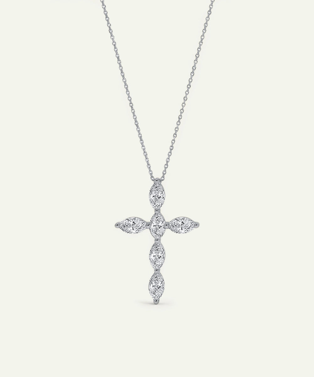 Silver cross-shaped pendant necklace on a light gray background