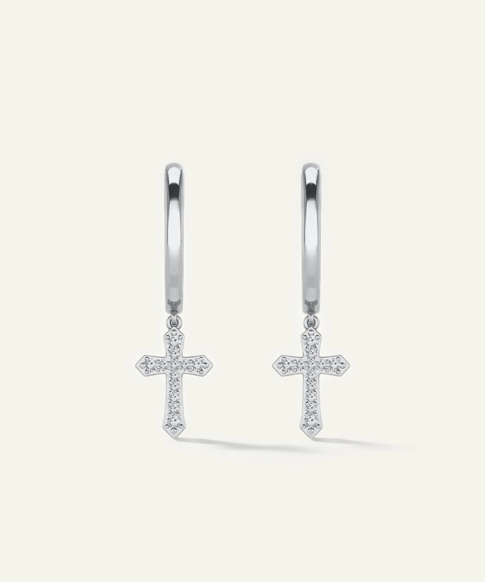 Silver cross earrings on a light gray background