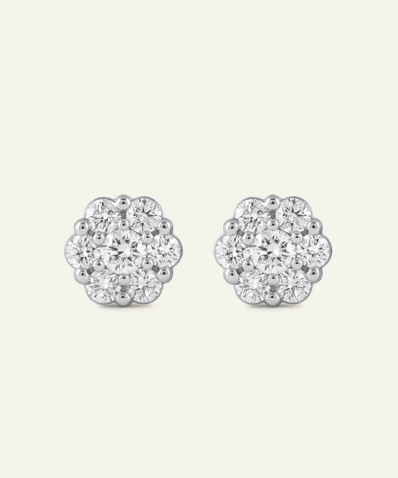Pair of silver floral earrings with clear gemstones on a white background