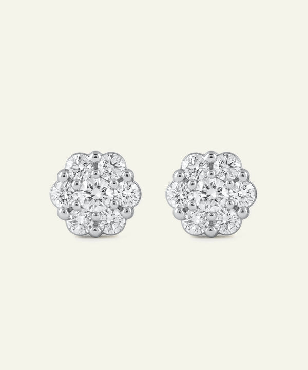 Pair of silver floral earrings with clear gemstones on a white background