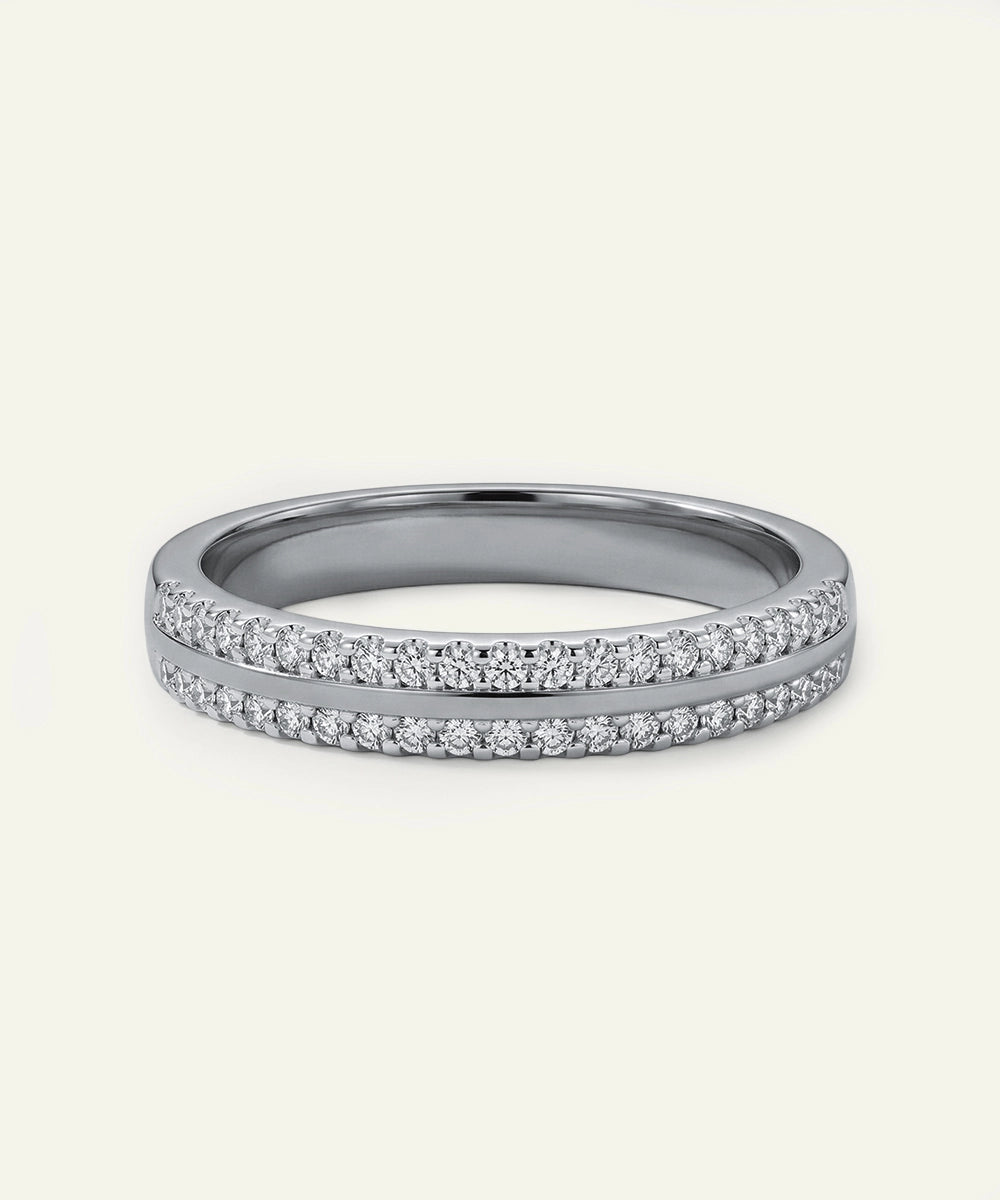 Silver ring with small diamonds on a light gray background