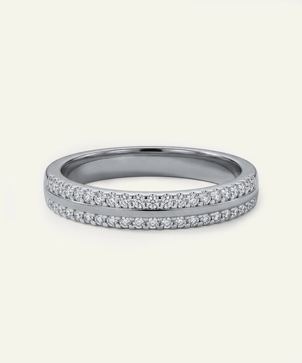 Silver ring with small diamonds on a light gray background