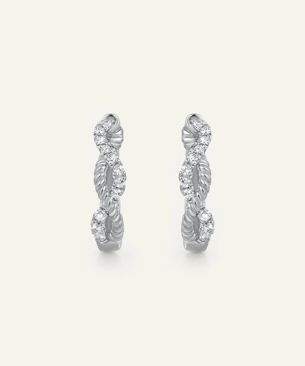 Pair of silver hoop earrings with diamond accents on a light gray background