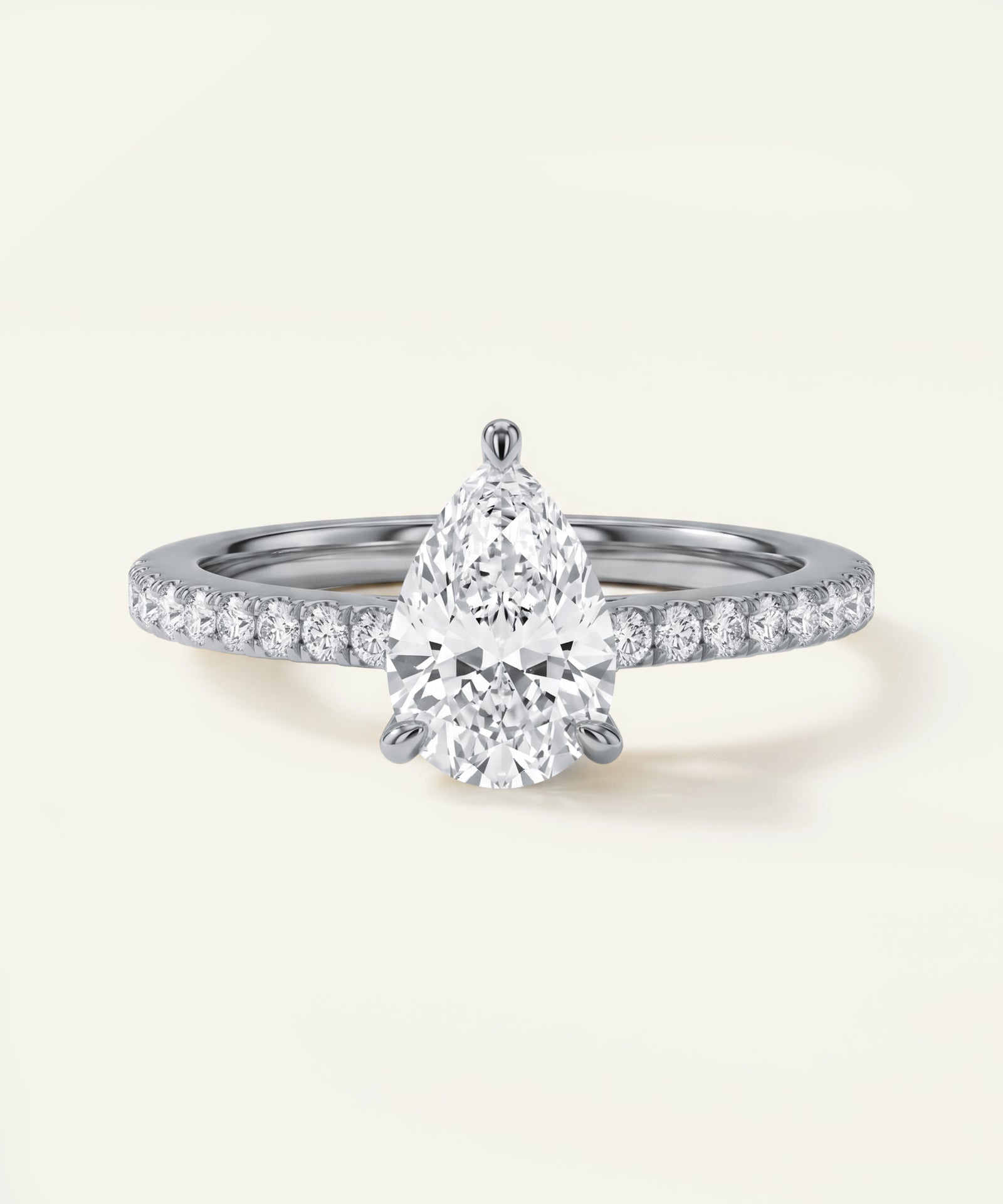 Diamond ring with a pear-shaped center stone on a light background