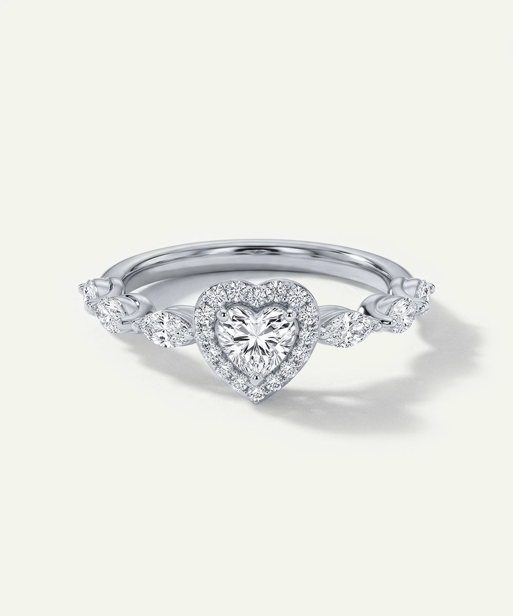 Diamond ring with heart-shaped center stone on a light gray background