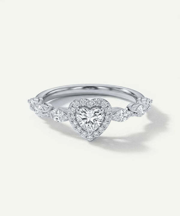 Diamond ring with heart-shaped center stone on a light gray background