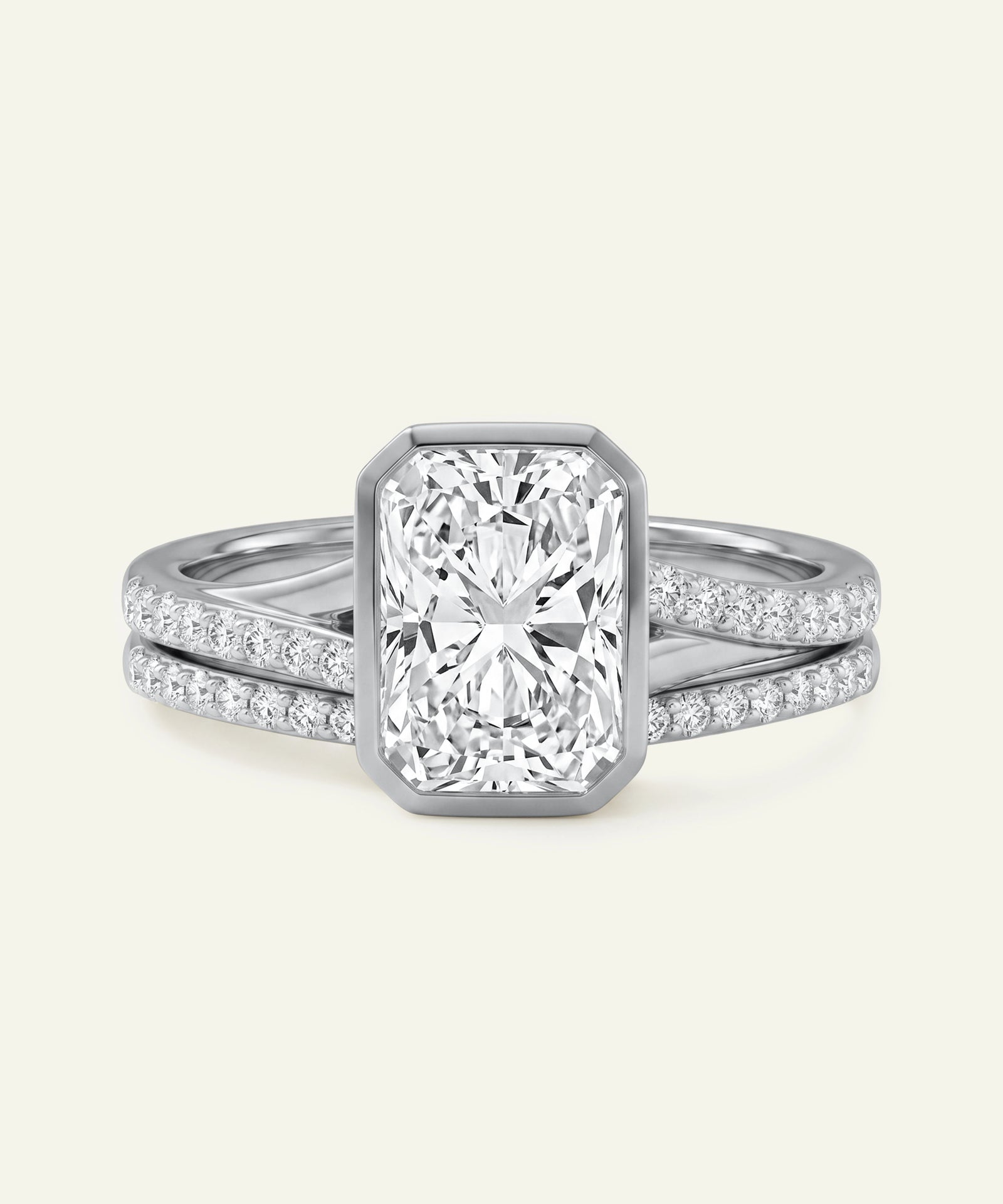 Diamond ring with a rectangular center stone on a light gray background