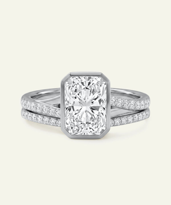 Diamond ring with a rectangular center stone on a light gray background