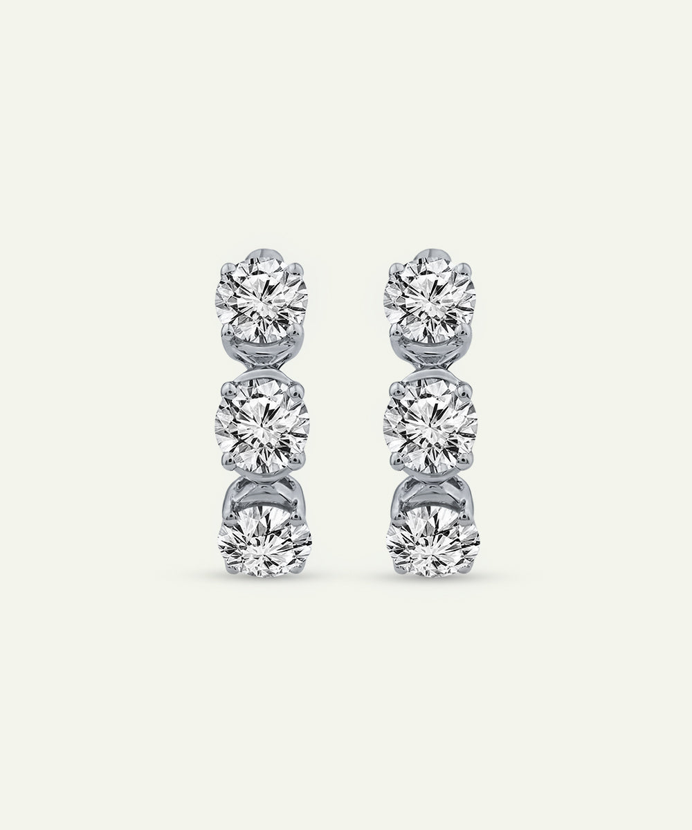 Pair of diamond stud earrings on a light gray background