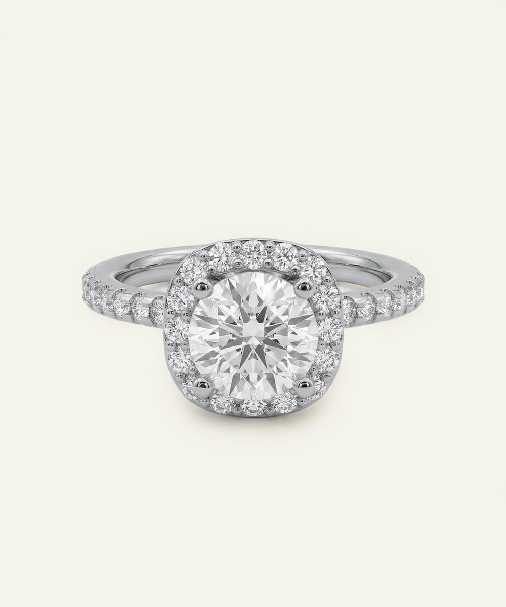 Diamond ring with a halo setting on a light gray background