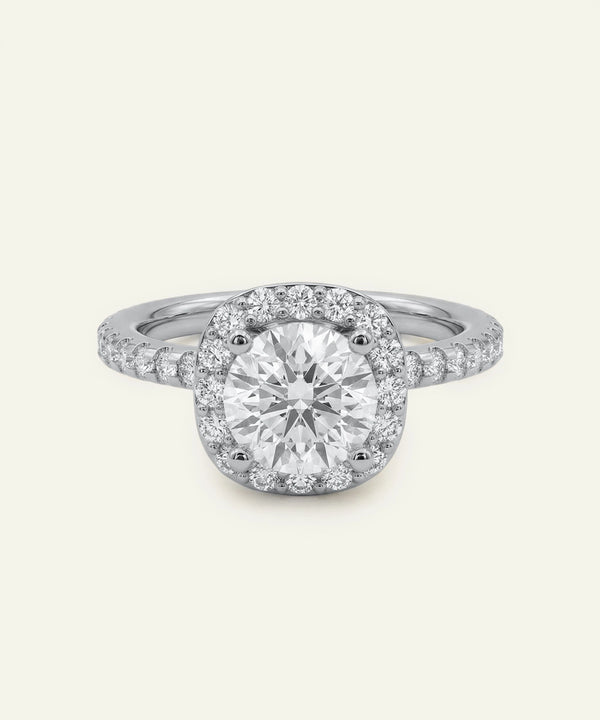 Diamond ring with a halo setting on a light gray background