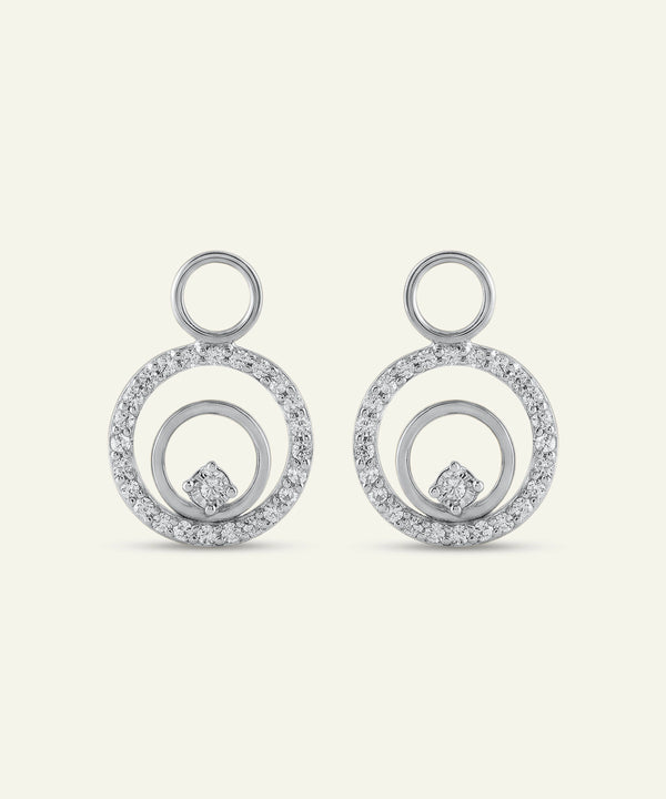 Pair of silver earrings with circular design on a light gray background