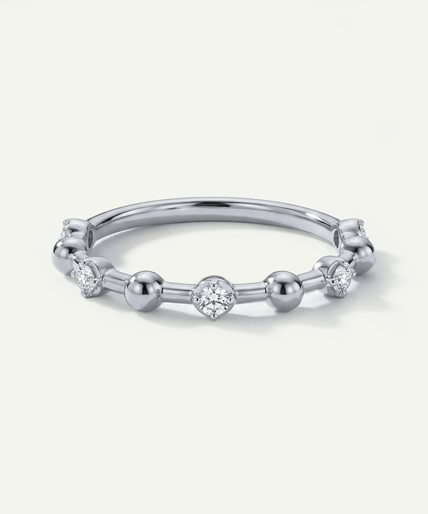 Silver ring with small diamonds on a light gray background