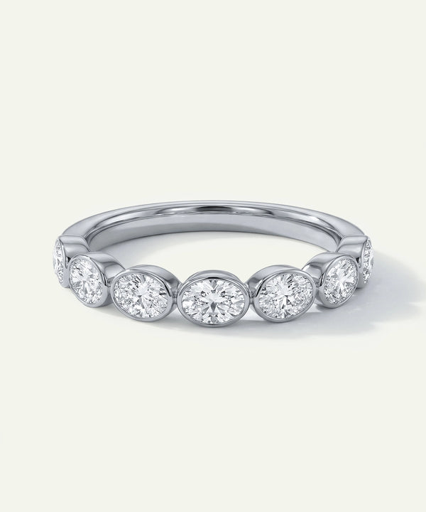 Silver ring with round diamonds on a light gray background