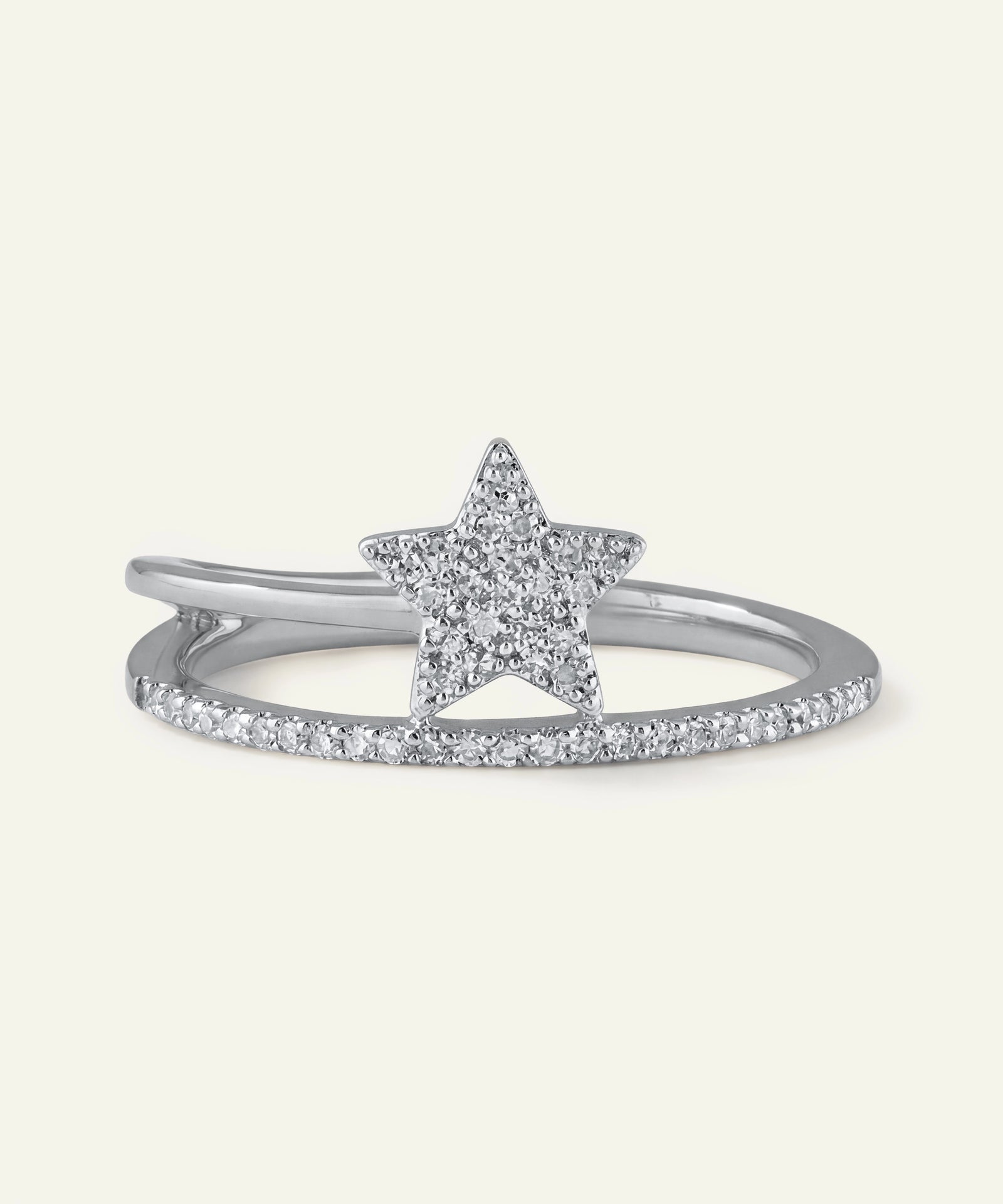 Star-shaped silver ring with small diamonds on a light gray background