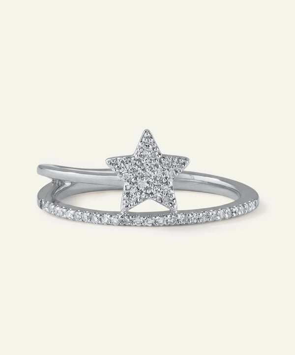 Star-shaped silver ring with small diamonds on a light gray background