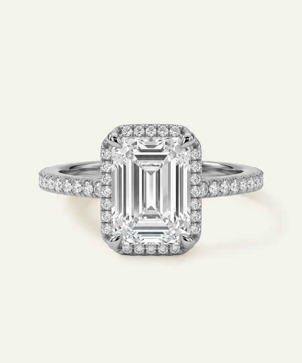 Diamond ring with a rectangular center stone on a light gray background