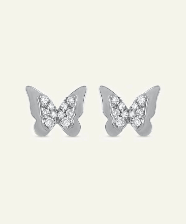Butterfly-shaped earrings with gemstones on a light gray background
