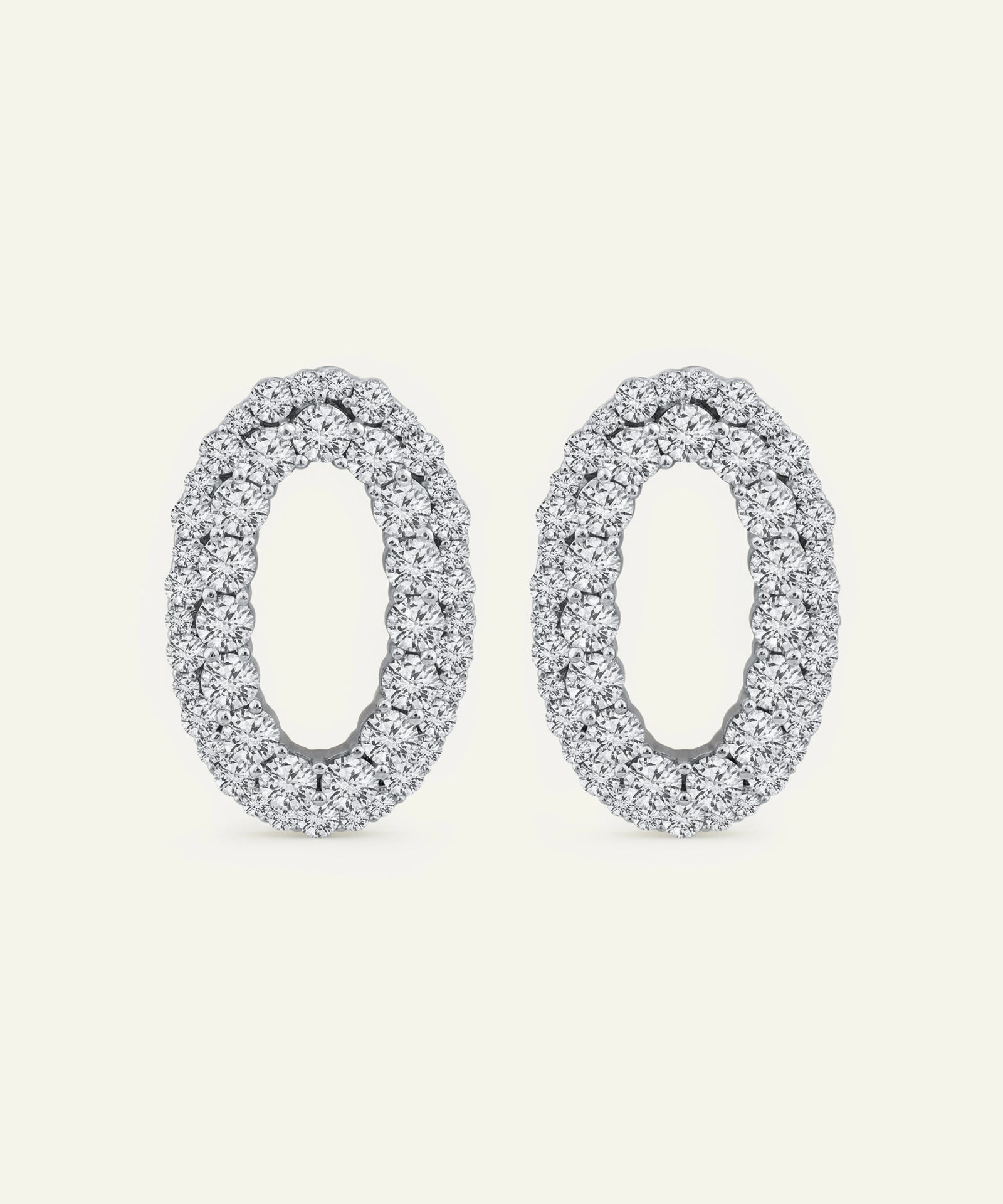 Pair of silver oval earrings on a white background