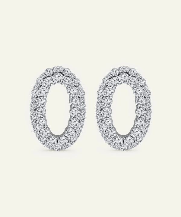 Pair of silver oval earrings on a white background