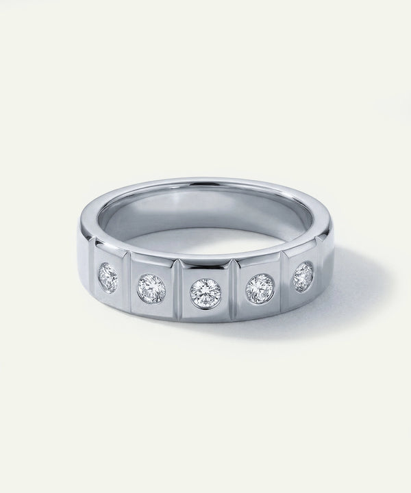 Silver ring with embedded diamonds on a light gray background