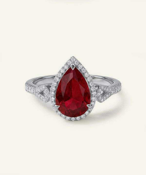 Ring with a red gemstone and diamond accents on a white background