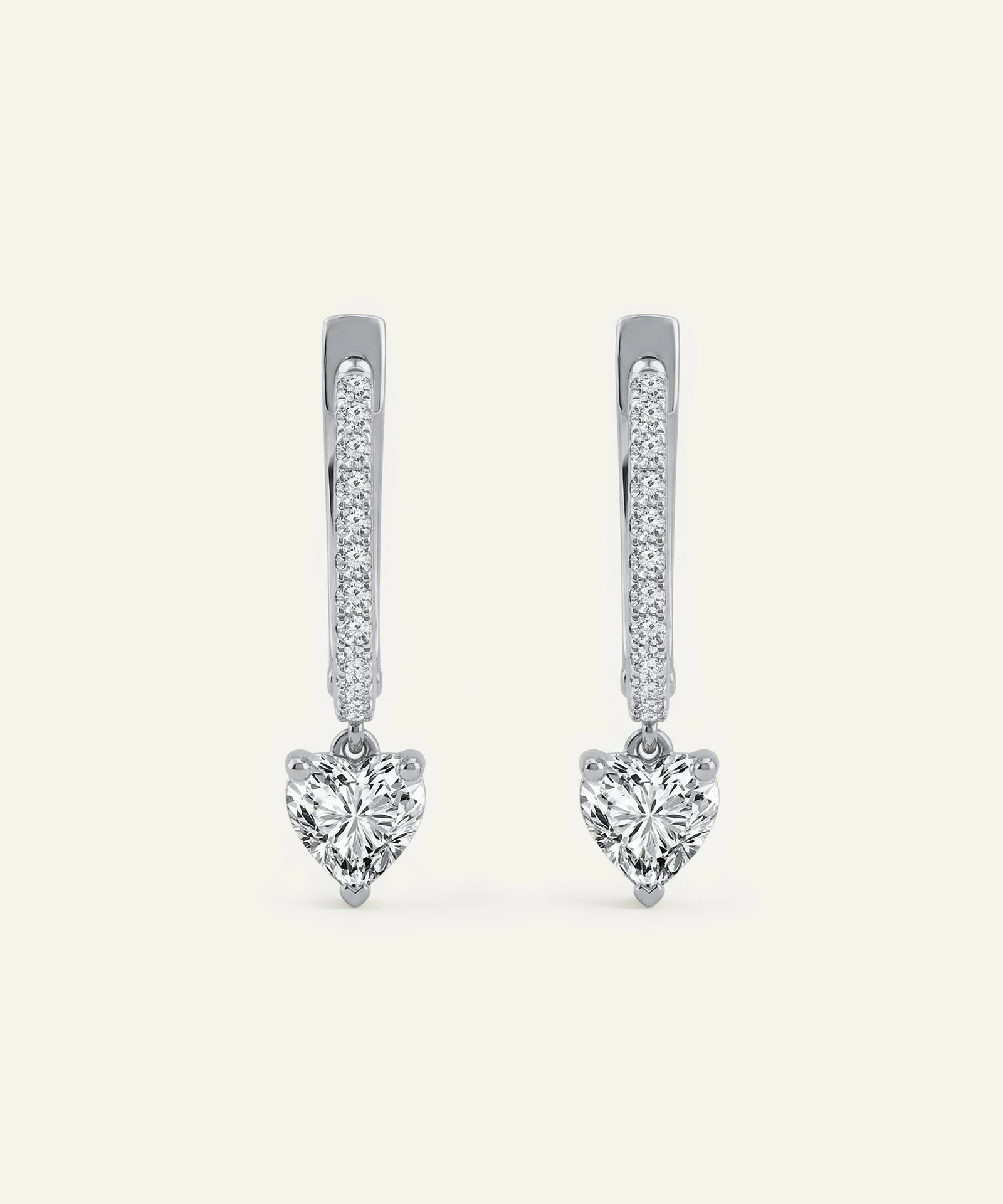Heart-shaped diamond earrings on a white background