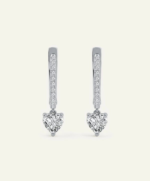 Heart-shaped diamond earrings on a white background