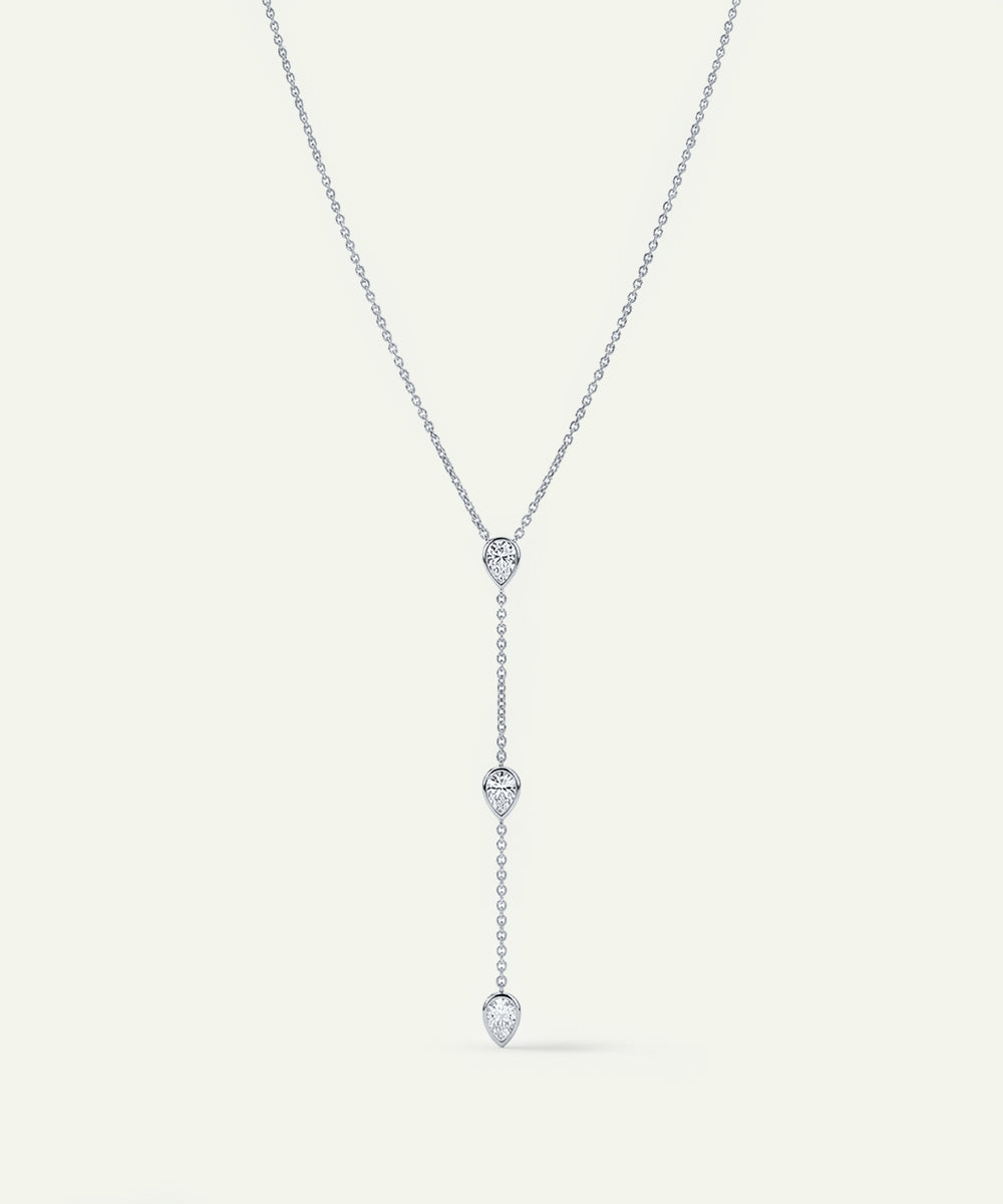 Silver necklace with heart-shaped pendant on a light gray background