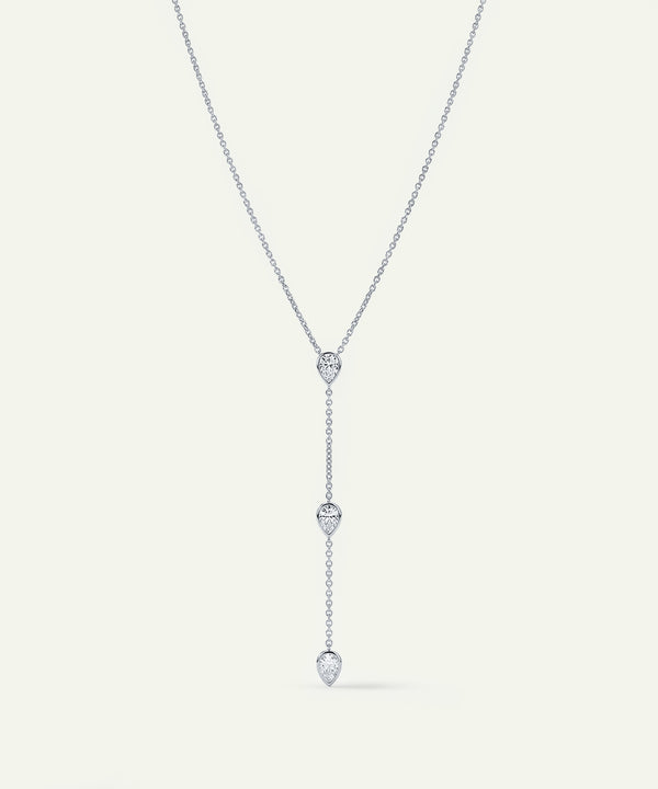 Silver necklace with heart-shaped pendant on a light gray background