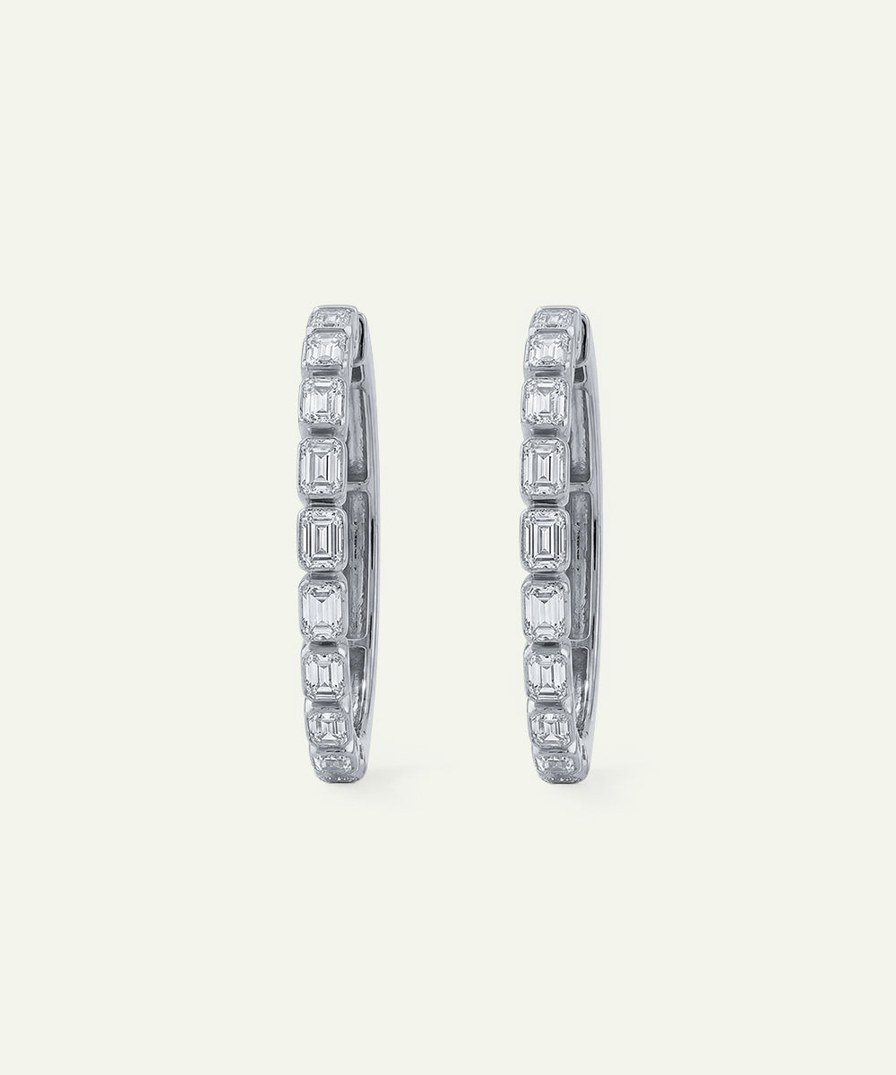 Pair of diamond hoop earrings on a light gray background