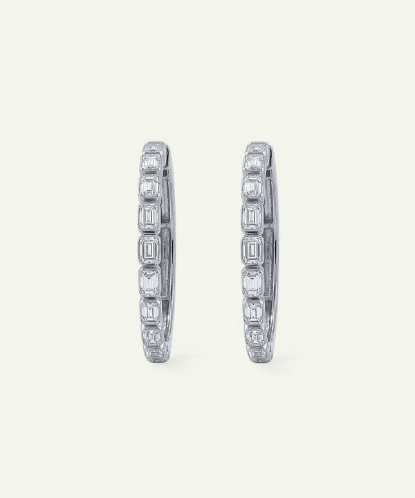 Pair of diamond hoop earrings on a light gray background